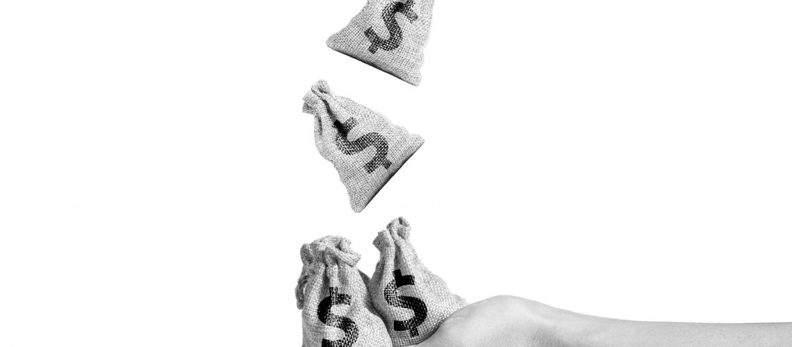 Isolate of US dollar bag drop ti hand which holding US dollar bag. Saving and investment concept.